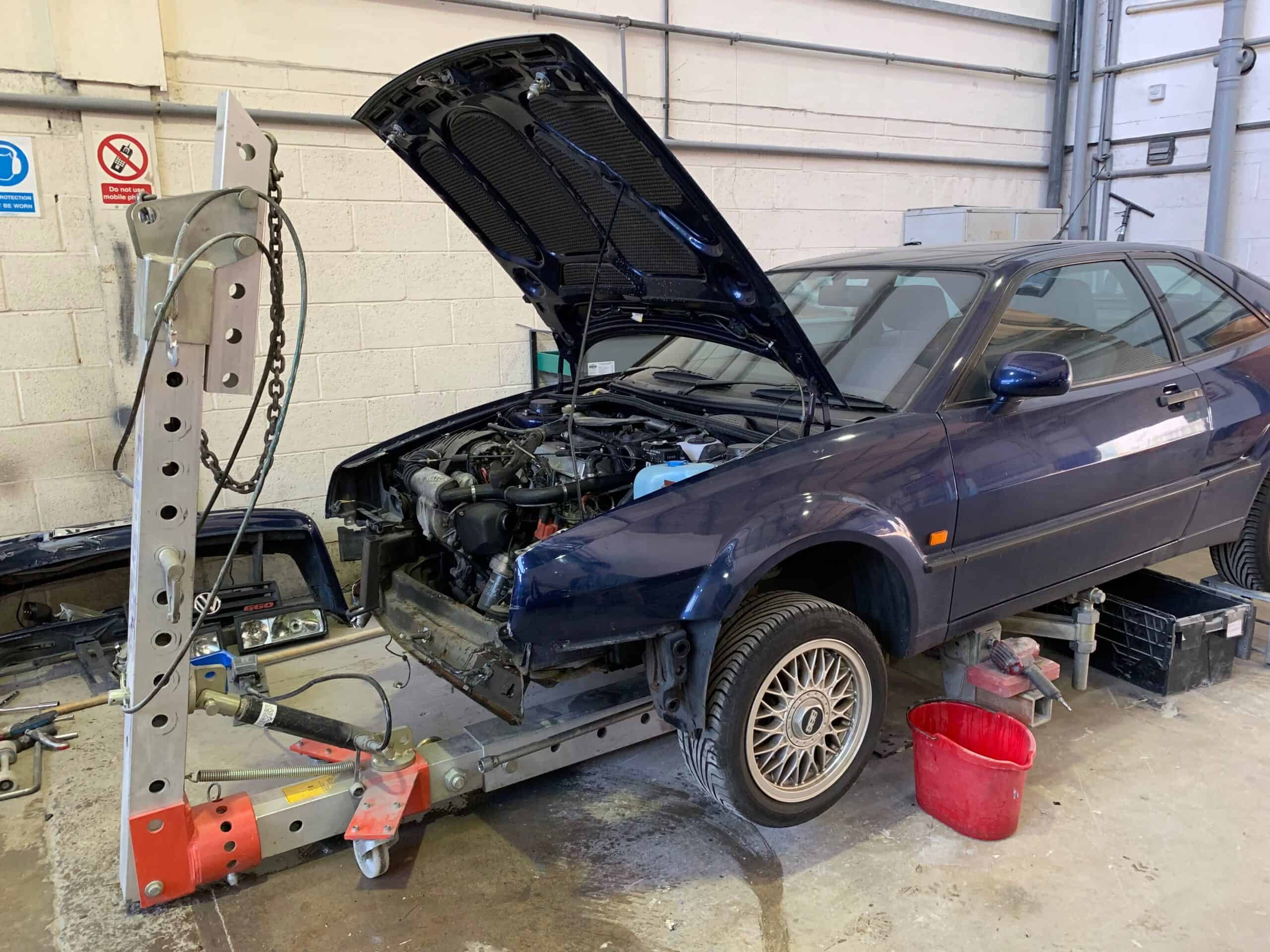 Engine repair on a damaged vehicle after a car accident. Skilled technicians restoring the car's eng.